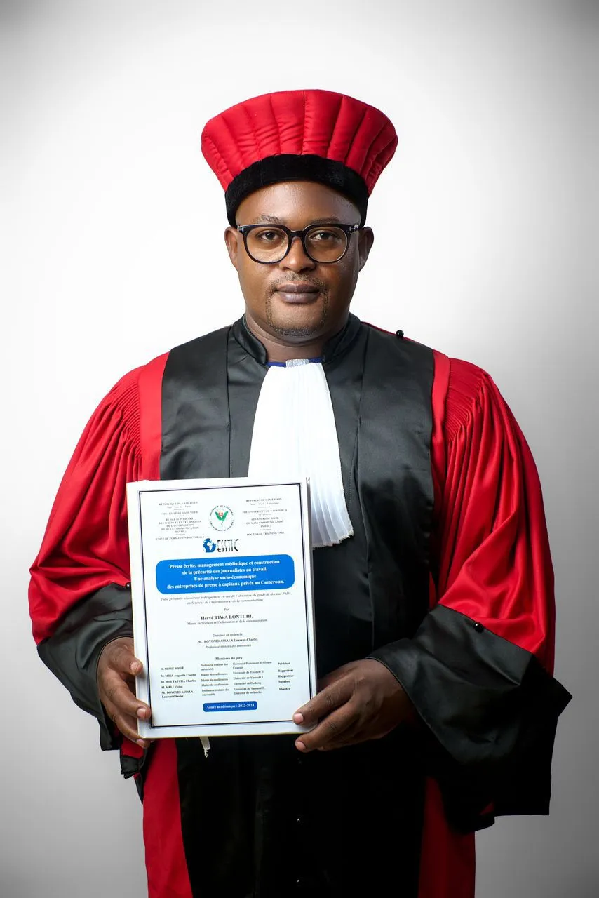 Hervé Tiwa avec sa thèse de doctorat entre les mains